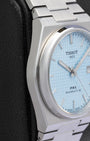 Left side view of the slim integrated case and smooth bezel profile on a 40mm Tissot PRX steel watch