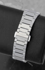 The seamless integrated stainless steel link bracelet and engraved butterfly clasp on a Tissot PRX watch