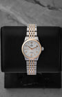 Pre-owned 2024 Tudor 1926 reference M91351 28mm ladies watch in stainless steel and rose gold, featuring a silver embossed waffle dial with gold hands and hour markers, displayed on a cushion.