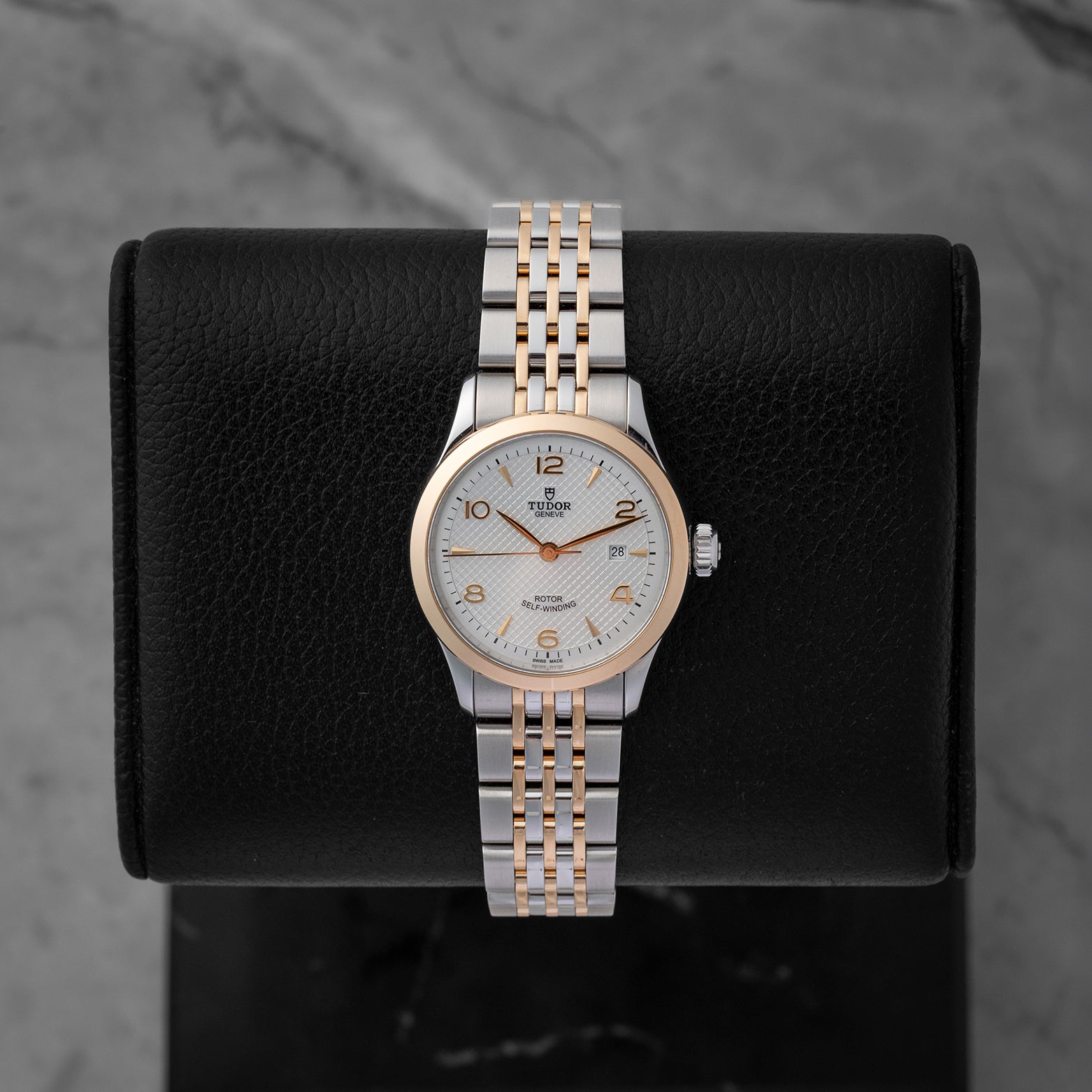 Pre-owned 2024 Tudor 1926 reference M91351 28mm ladies watch in stainless steel and rose gold, featuring a silver embossed waffle dial with gold hands and hour markers, displayed on a cushion.