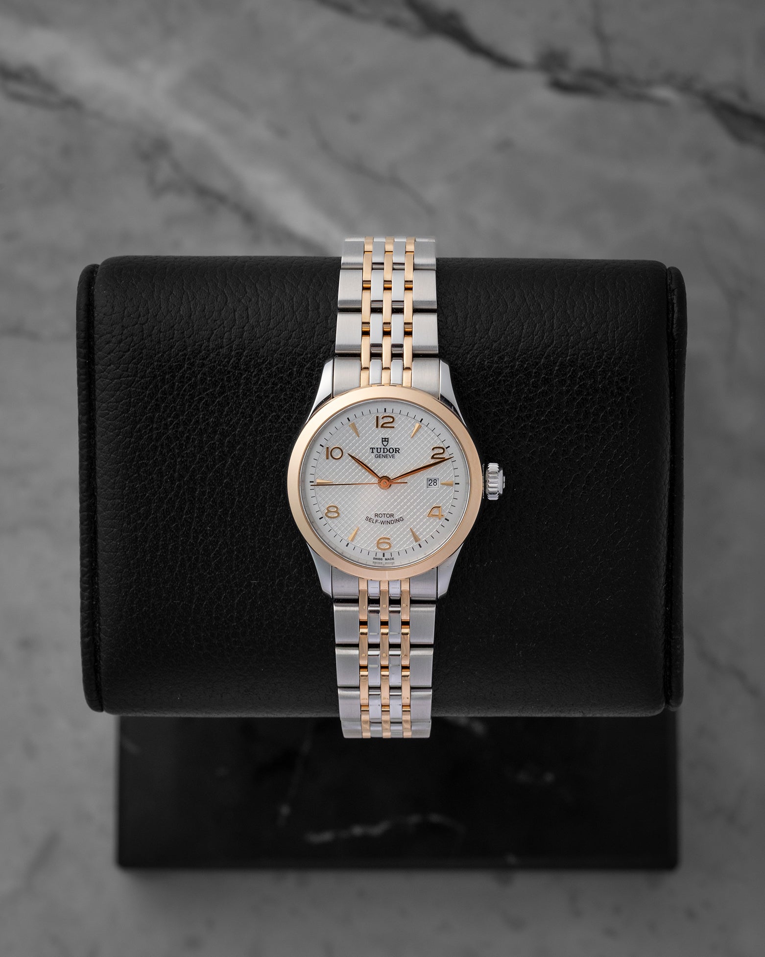 Pre-owned 2024 Tudor 1926 reference M91351 28mm ladies watch in stainless steel and rose gold, featuring a silver embossed waffle dial with gold hands and hour markers, displayed on a cushion.