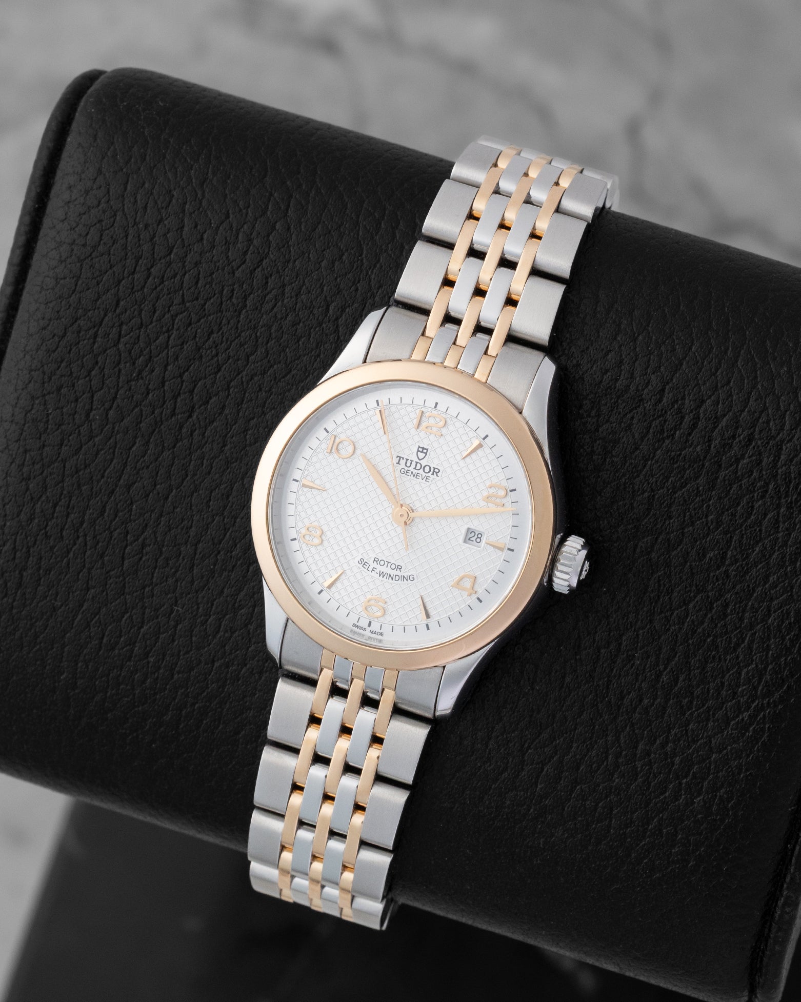 Angled shot of a pre-owned 2024 Tudor 1926 reference M91351 showing the silver textured dial, rose gold smooth bezel, and two-tone steel and rose gold multi-link bracelet.