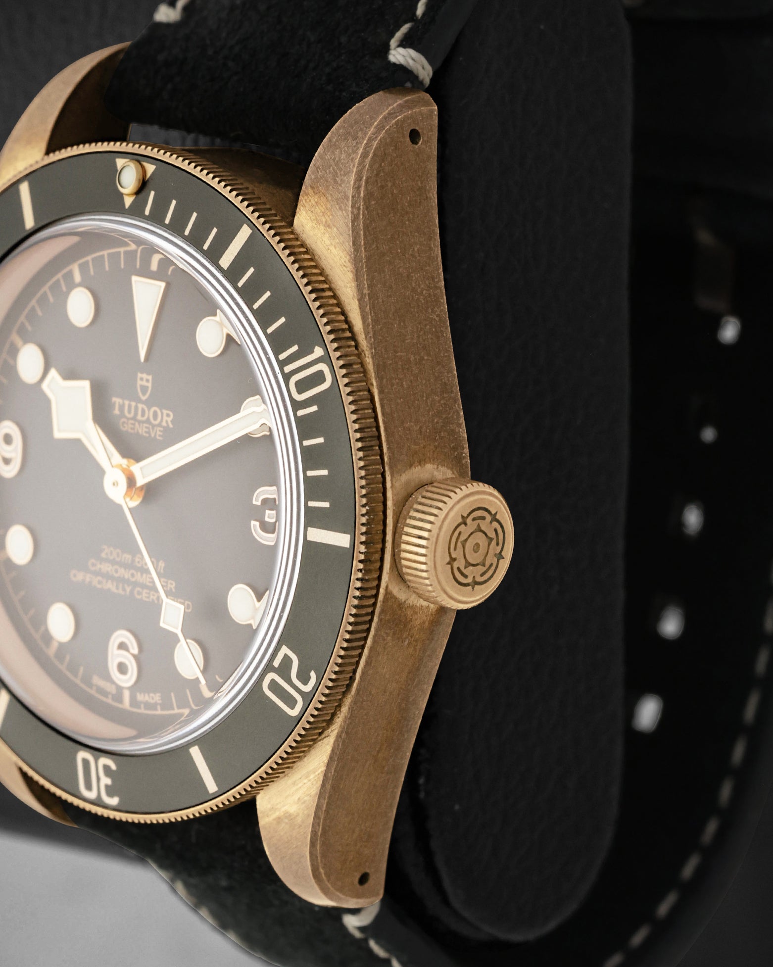 Side profile focus on the natural patinated bronze case finish and the prominent screw-down winding crown engraved with the Tudor rose