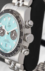 Side profile view of the stainless steel case showing the black tachymeter bezel signed crown and vintage-style screw-down chronograph pushers