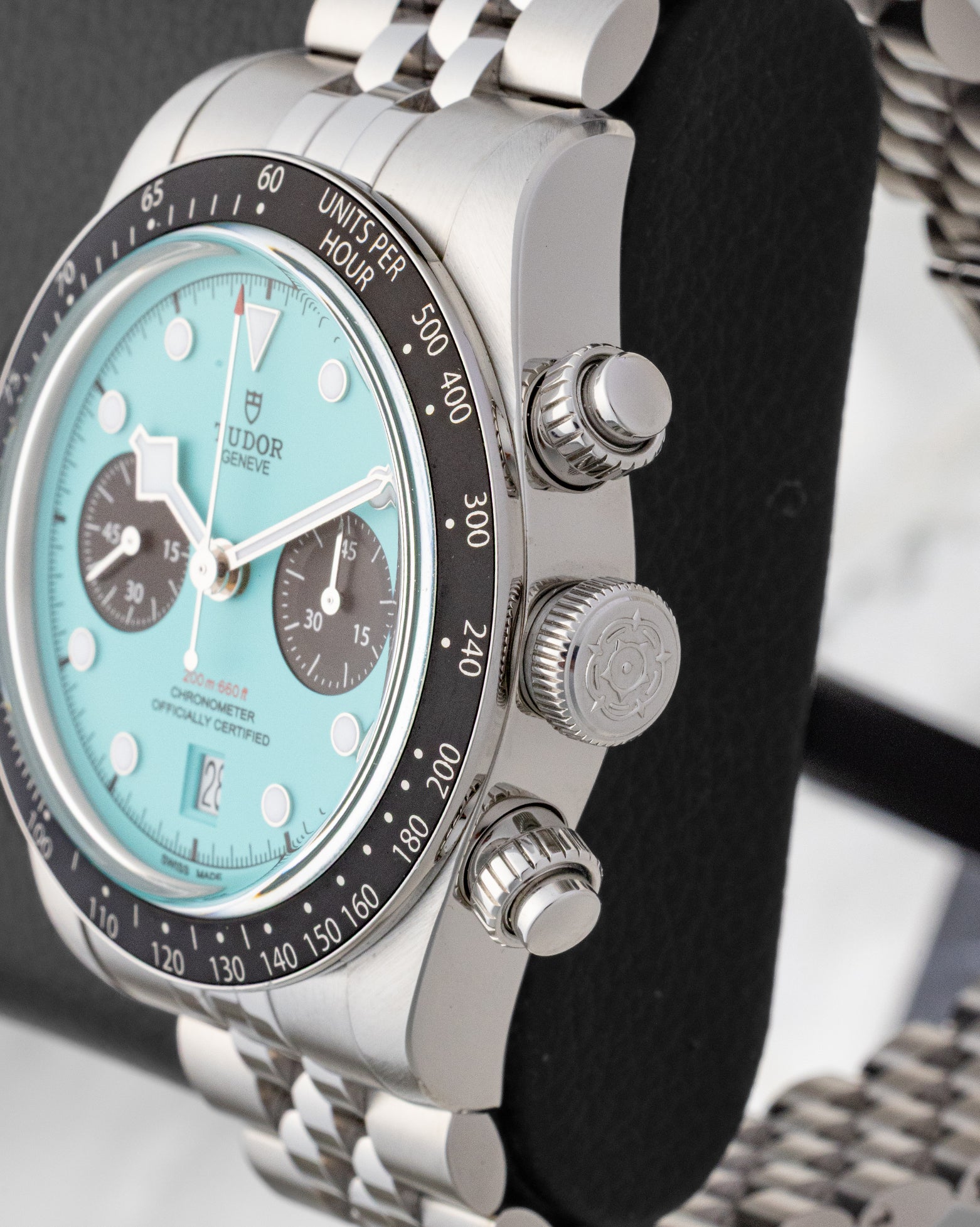 Side profile view of the stainless steel case showing the black tachymeter bezel signed crown and vintage-style screw-down chronograph pushers