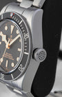Close-up of the large winding crown and brushed steel case profile on a Tudor Black Bay 41mm watch