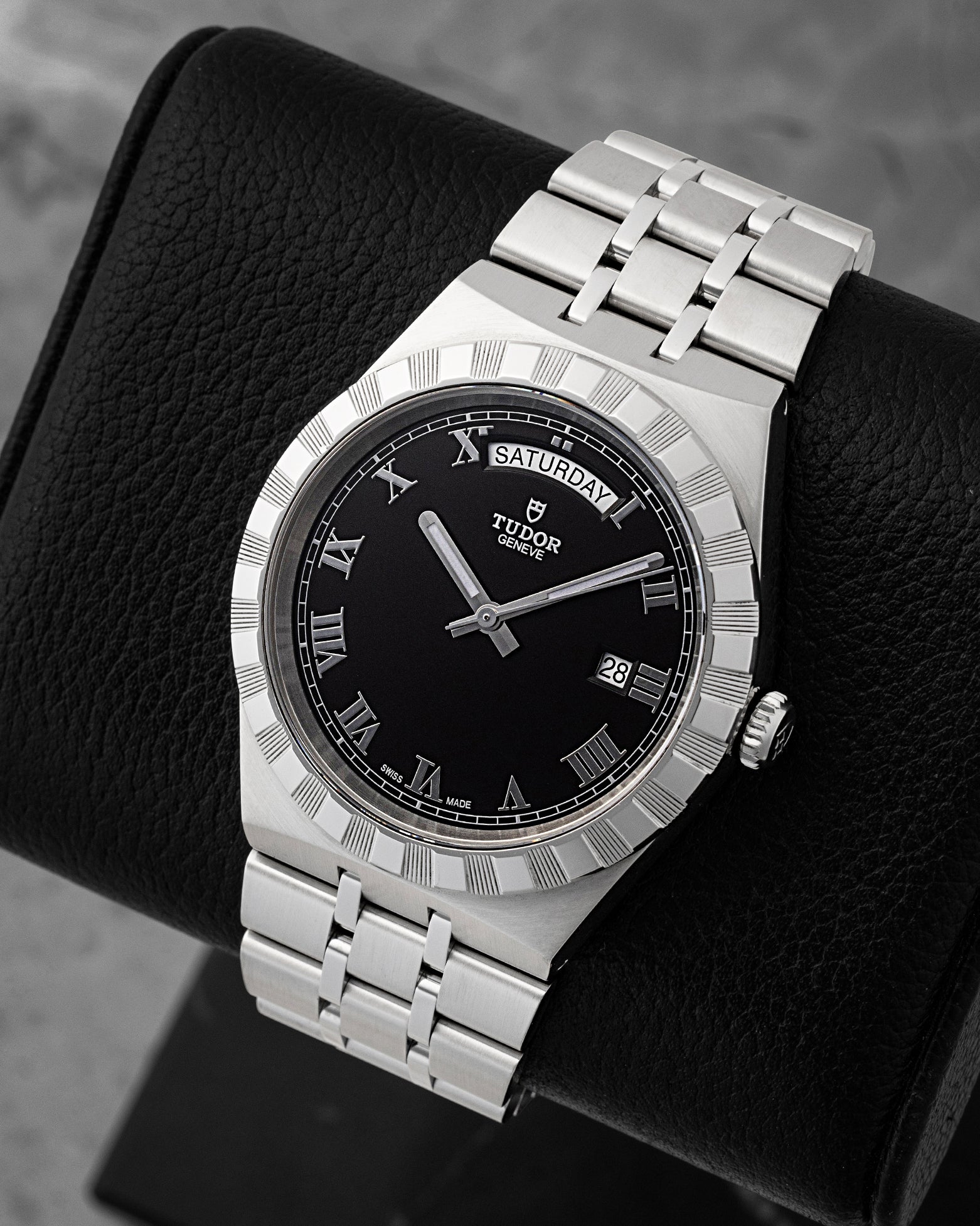 Angled view of pre-owned Tudor Royal Day-Date M28600 featuring a black dial, applied silver Roman numerals, day window at 12 o'clock, and date at 3 o'clock