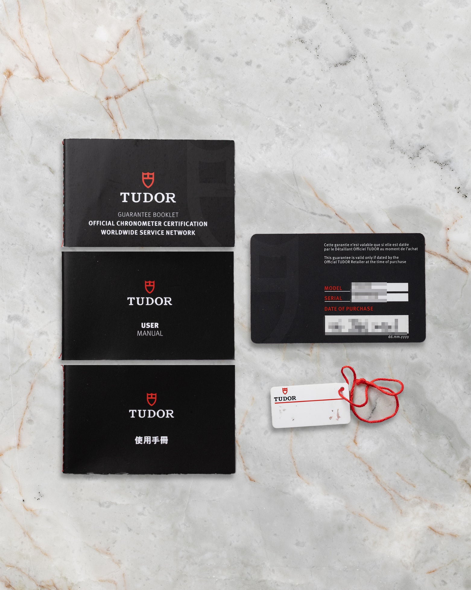 Original Tudor international guarantee card, user manual booklets, and serial hangtag included with pre-owned Tudor Royal M28600 set