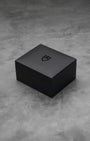 Official minimalist textured matte black square Tudor presentation watch box sitting on marble