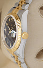Side profile focus on the Oystersteel case architecture and the 18k yellow gold screw-down winding crown of the reference 116233