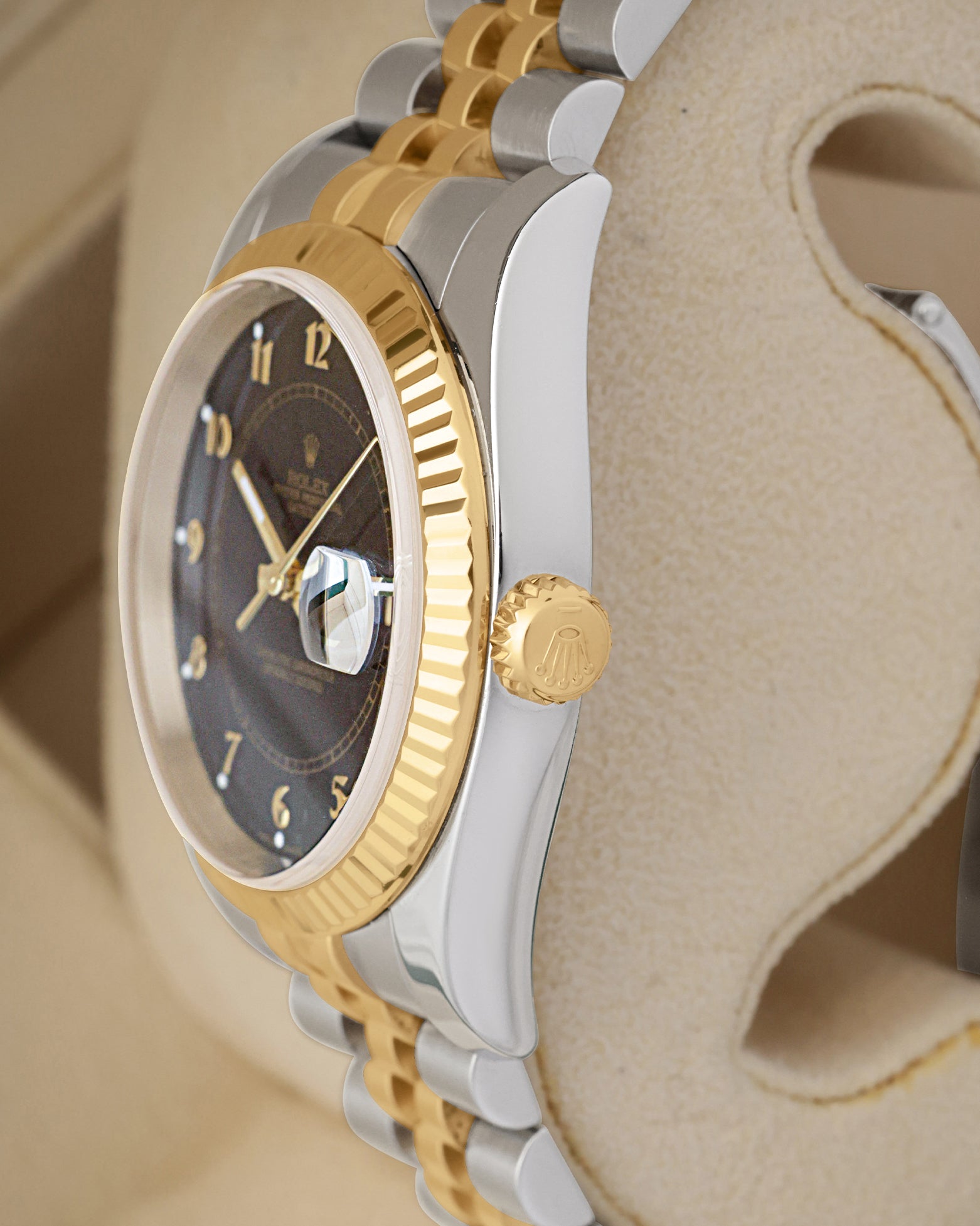 Side profile focus on the Oystersteel case architecture and the 18k yellow gold screw-down winding crown of the reference 116233