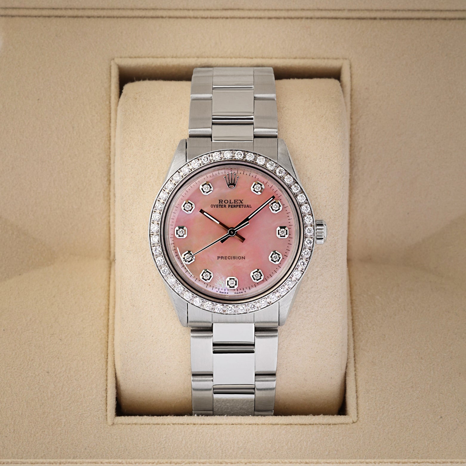 A vintage 1964 Rolex Oyster Perpetual 34 reference 1002 featuring a custom pink MOP dial, diamond hour markers, and a custom diamond-set bezel inside its box at Noah's Fine Watches & Jewelry in Dallas