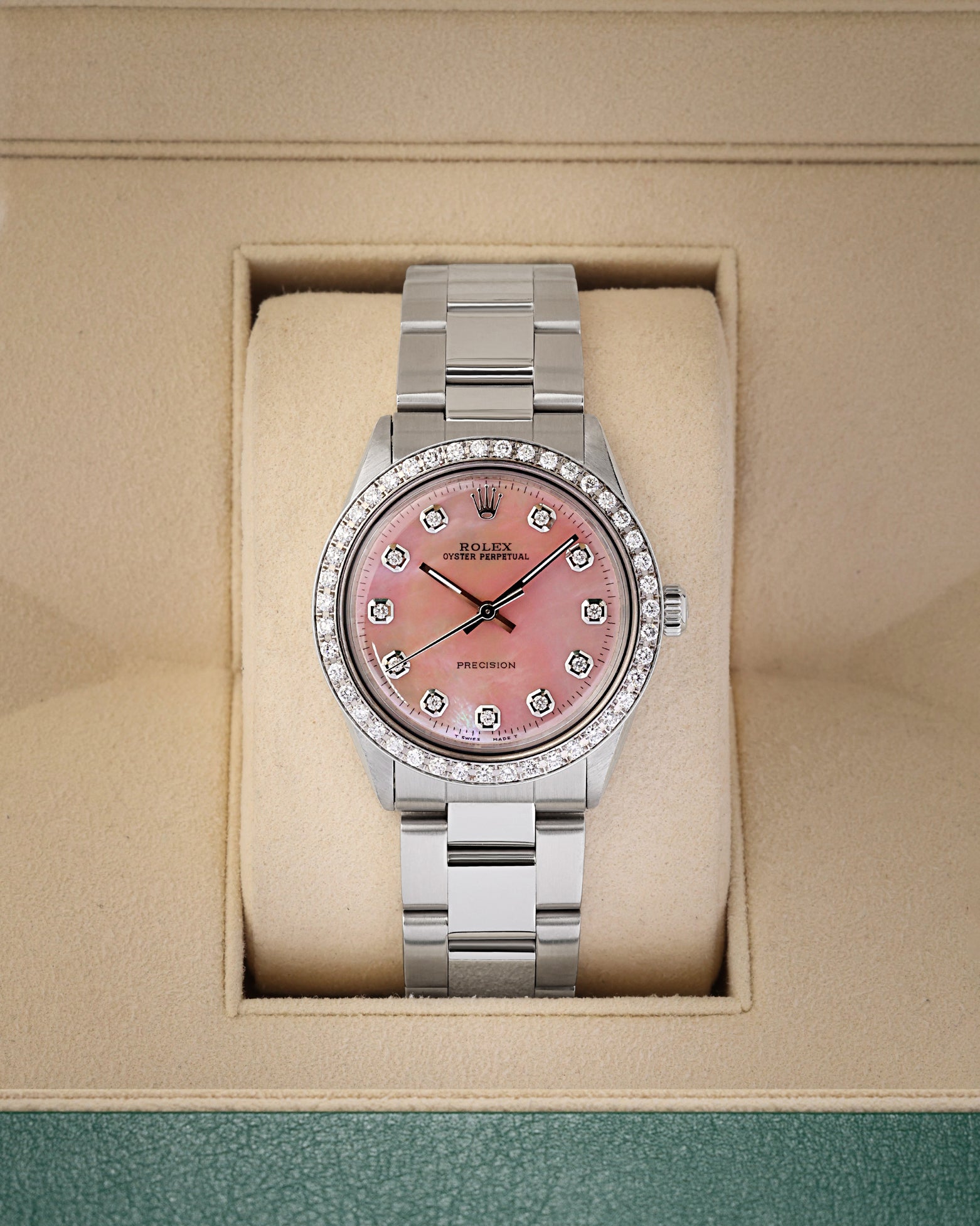 A vintage 1964 Rolex Oyster Perpetual 34 reference 1002 featuring a custom pink MOP dial, diamond hour markers, and a custom diamond-set bezel inside its box at Noah's Fine Watches & Jewelry in Dallas