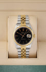 A vintage 1988 Rolex Datejust 36 reference 16233 in two-tone stainless steel and 18k yellow gold featuring a glossy black dial and Jubilee bracelet inside its box at Noah's Fine Watches & Jewelry in Dallas