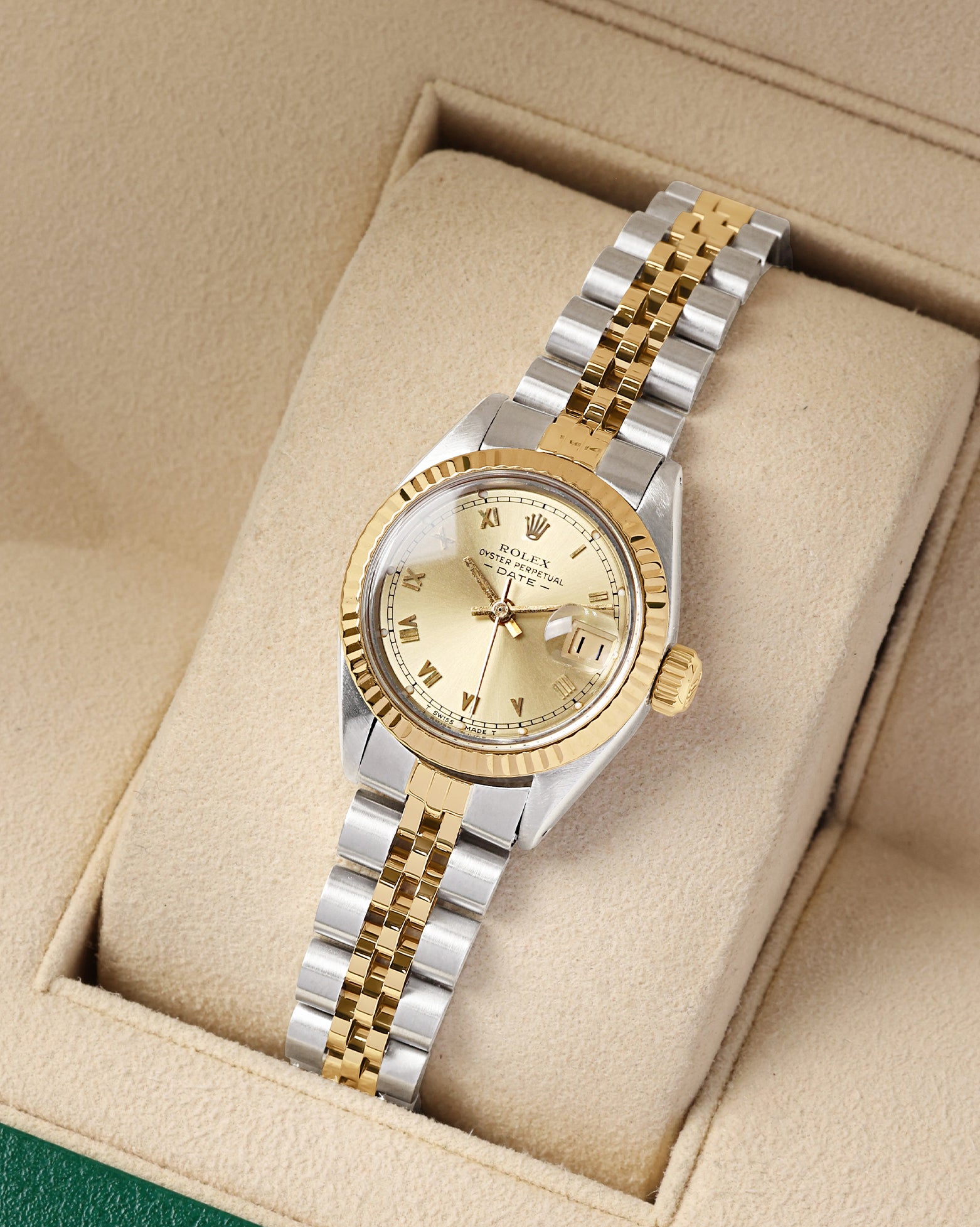 A high-angle three-quarter portrait of the 26mm two-tone luxury watch case showcasing its 14k yellow gold fluted bezel upgrade and matching steel and gold Jubilee links