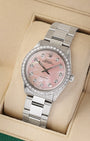 studio portrait of the 34mm stainless steel Rolex case showcasing the custom diamond indices and flat-brushed Oyster links on a beige display cushion