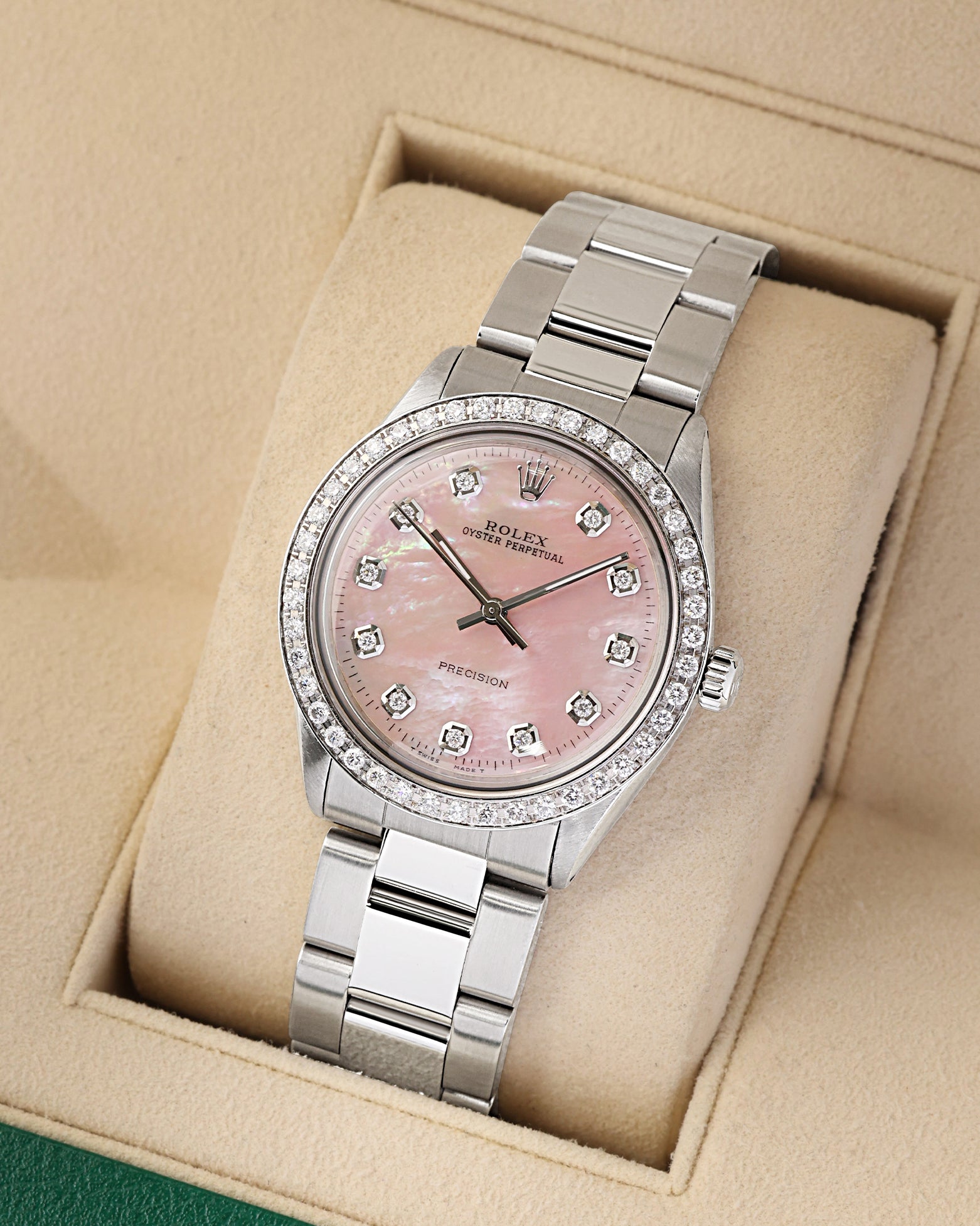 studio portrait of the 34mm stainless steel Rolex case showcasing the custom diamond indices and flat-brushed Oyster links on a beige display cushion