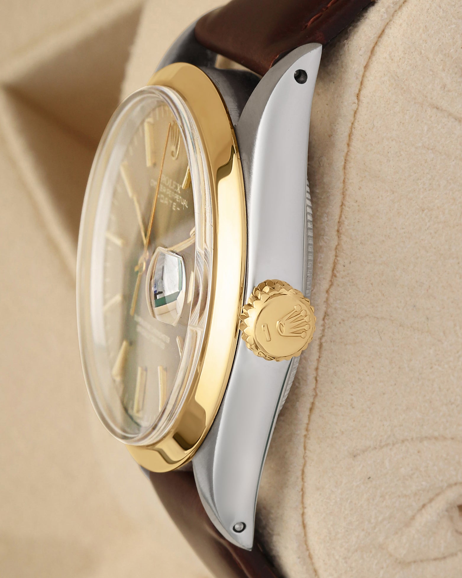 Close-up right profile view of the watch head highlighting the high-dome vintage acrylic Plexiglass crystal, the smooth gold bezel, and the fluted yellow gold Twinlock winding crown