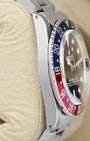 left-side case profile view of a vintage 40mm stainless steel Rolex Oyster case with a thin Pepsi bezel profile resting on a cushion