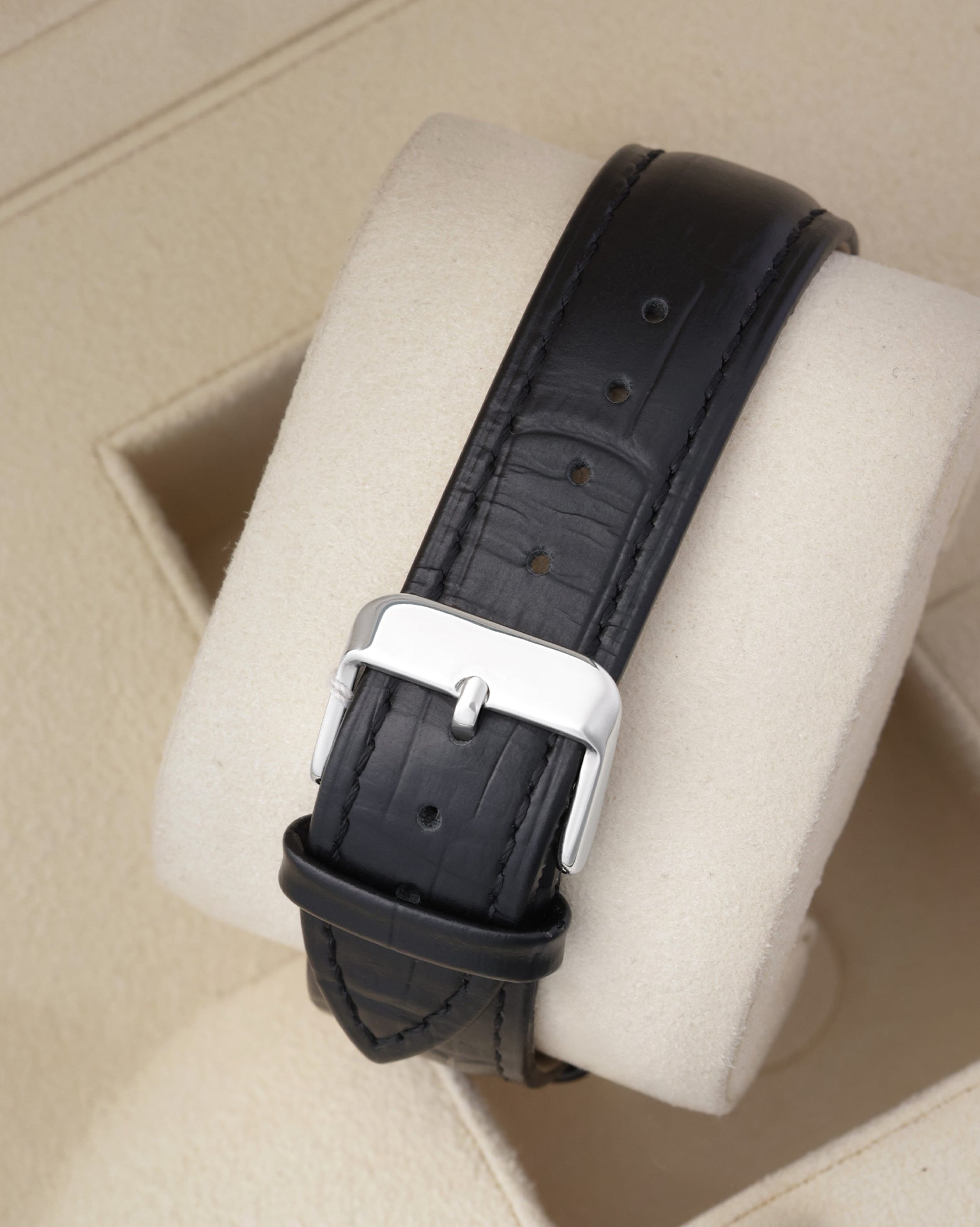 Rear view of the smooth black leather watch strap highlighting the polished stainless steel tang buckle closure