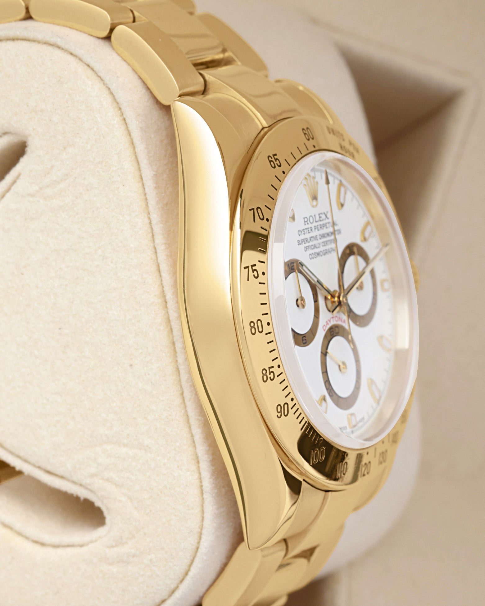 Side profile view of the mirror-polished solid 18k yellow gold Oyster case on the non-crown side of a Rolex Daytona 40mm
