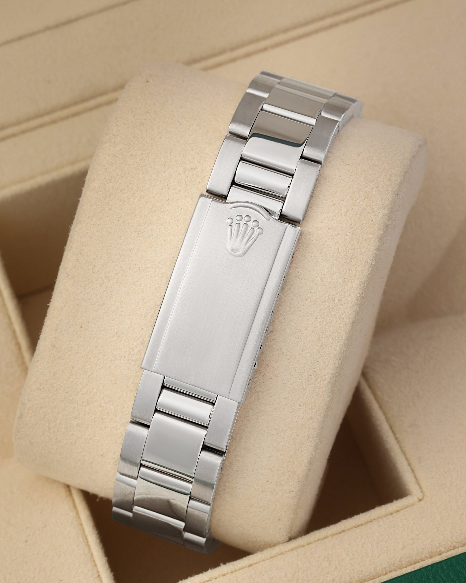 A rear view of the stainless steel Oyster metal link watch band focusing on the secure closure of the vintage fold-over deployant clasp detailed with an embossed Rolex crown logo