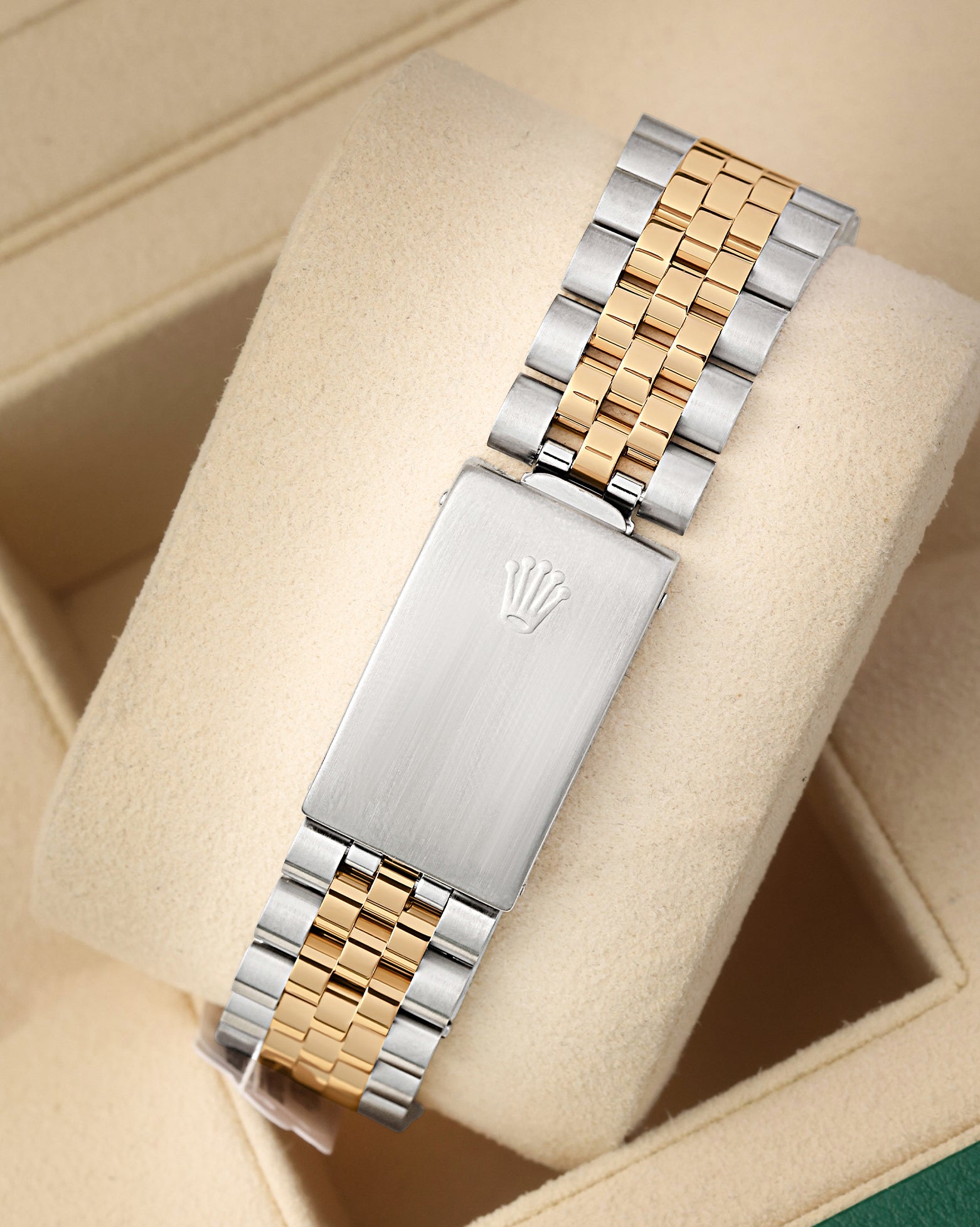 A rear view of the vintage two-tone metal watch band focusing on the secure closure of the classic stainless steel fold-over deployant clasp detailed with an embossed Rolex crown logo