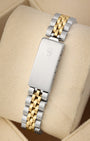 A rear view of the vintage two-tone watch band focusing on the secure closure of the classic stainless steel fold-over deployant clasp detailed with an embossed Rolex crown logo