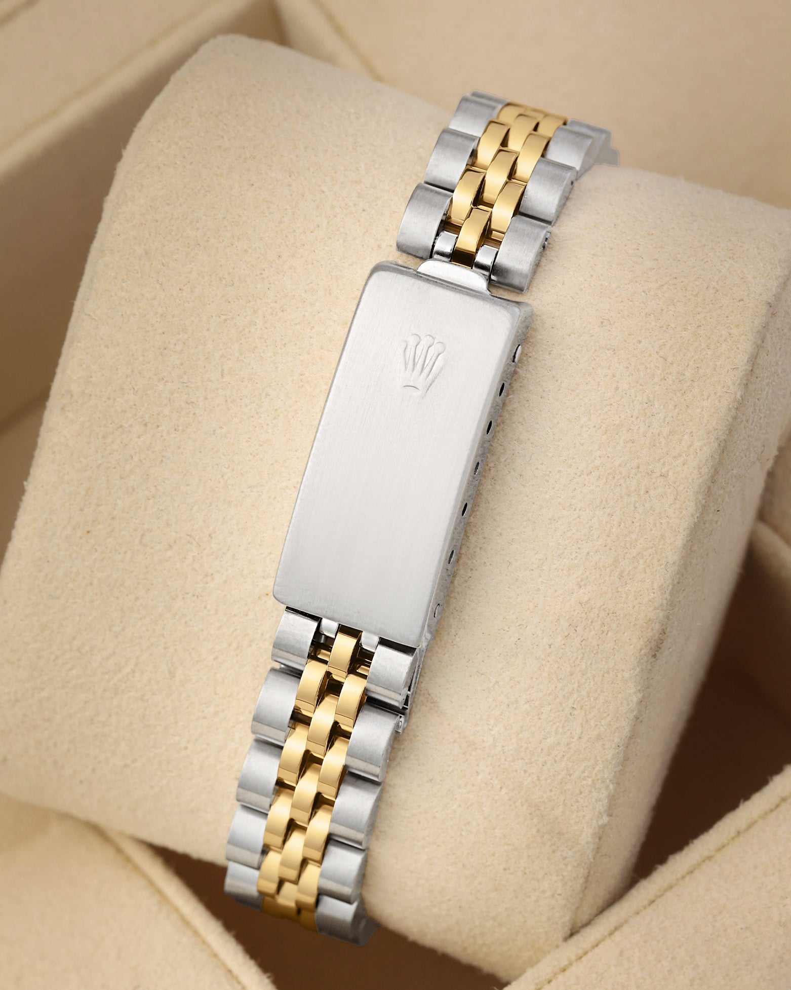 A rear view of the vintage two-tone watch band focusing on the secure closure of the classic stainless steel fold-over deployant clasp detailed with an embossed Rolex crown logo