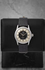 frontal portrait of a vintage 1950s Tudor Oyster Prince 7950 watch with a black and cream Tuxedo sector dial on a leather display mount